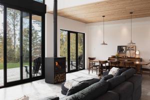 a living room with a couch and a fireplace at Le Ruisseau: luxurious villa in Charlevoix. in La Malbaie