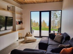 a living room with a couch and a large window at Le Ruisseau: luxurious villa in Charlevoix. in La Malbaie