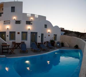 a villa with a swimming pool in front of a house at Villa Murano in Fira