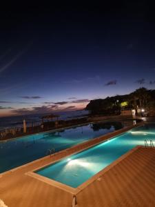 una piscina por la noche con el océano en el fondo en Villa Giorgia Cilento, en Montecorice