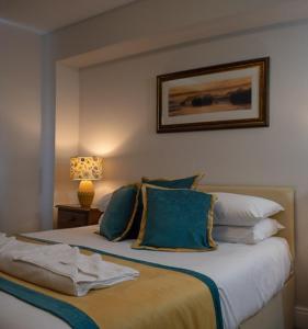 a bedroom with a large bed with blue pillows at Meadowcroft Guest House in Windermere