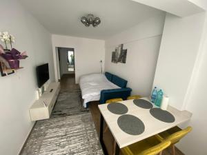 um pequeno quarto com uma cama e uma mesa em Blue Tower Apartments em Suceava