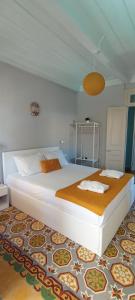 1 dormitorio con 1 cama blanca grande con alfombra en Kosta n`tina Guest House, en Lefkada