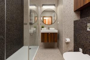 a bathroom with a shower and a sink and a mirror at Trendy & Spacious 3-room Apartament Warsaw Wilanów by Renters in Warsaw
