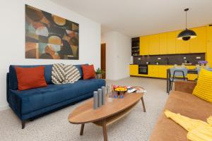 a living room with a blue couch and a table at Trendy & Spacious 3-room Apartament Warsaw Wilanów by Renters in Warsaw