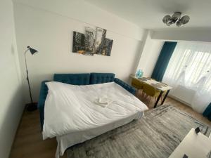 um pequeno quarto com uma cama e uma mesa em Blue Tower Apartments em Suceava