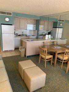 La cuisine est équipée d'une table, de chaises et d'un réfrigérateur. dans l'établissement Barclay Towers, à Virginia Beach
