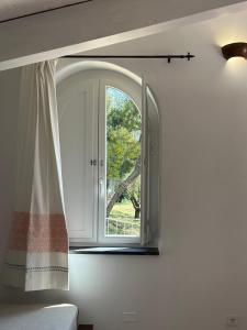 a bedroom with an arched window and a bed at Hotel Villa Cedrino in Dorgali