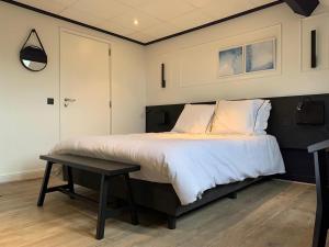 a bedroom with a large bed and a table at Hotel Dunepanne in De Haan