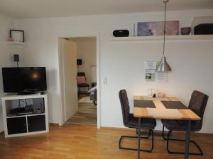 a dining room with a table and chairs and a television at Ferienwohnung Butscher in Isny im Allgäu