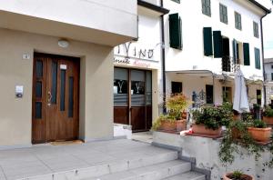 a building with a wooden door and some potted plants at Break Affittacamere in San Vito al Tagliamento