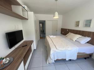 ein Schlafzimmer mit einem Bett und einem Flachbildfernseher in der Unterkunft Pipa Ubaia Residence 121 in Pipa