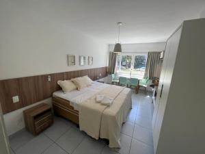 ein Schlafzimmer mit einem Bett und einem Tisch und Stühlen in der Unterkunft Pipa Ubaia Residence 121 in Pipa + 15 Fotos