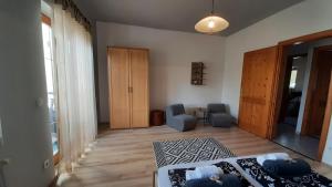a living room with a bed and a chair and a window at Selyemakàc apartman in Zalakaros