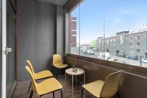 a room with chairs and a table and a window at Tower Apartments in Reykjavík