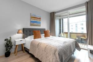 1 dormitorio con cama y ventana grande en Tower Apartments en Reikiavik