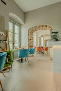 a living room with blue chairs and a table at Impero Nafplio Hotel & Suites in Nafplio