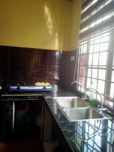 un comptoir de cuisine avec deux lavabos et une fenêtre dans l'établissement Sobey Laris Homestay QASEH, à Pasir Mas