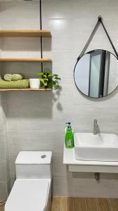 ein Badezimmer mit einem weißen Waschbecken und einem Spiegel in der Unterkunft VANIA HOUSE - cozy studio near the airport in Ho-Chi-Minh-Stadt