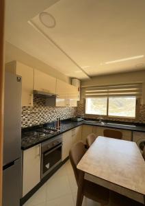 - une cuisine avec une table et un comptoir dans l'établissement bel appartement équipé et spacieux avec vue magnifique sur mer, à Al Hoceïma