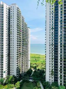 two tall white buildings with a road between them at Sea&CityView 2-bedroom Fully Furnished Apartment Forest City #freeWIFI in Gelang Patah
