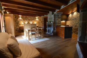 a living room with a couch and a kitchen with a table at Hotel Rural El Portón de Murillo in Broto