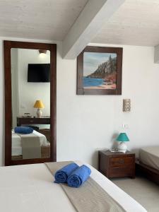 a bedroom with two beds and a mirror at Hotel Villa Cedrino in Dorgali