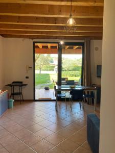 ein großes Wohnzimmer mit einem Tisch und Stühlen in der Unterkunft Casa degli Ulivi in Padenghe sul Garda