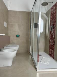 a bathroom with a toilet and a glass shower at Hotel Villa Cedrino in Dorgali