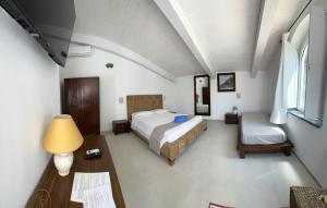 a bedroom with a bed and a table and a lamp at Hotel Villa Cedrino in Dorgali
