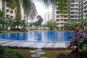 une grande piscine avec des palmiers et des bâtiments dans l'établissement Johor Bahru Danga Bay Country Garden 2BR 18 Home+, à Johor Bahru
