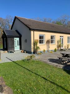 een gebouw met een picknicktafel ervoor bij Owlswood Apartments in Edinbain