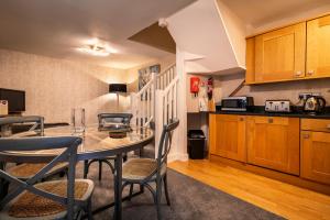 a kitchen with a table and chairs in a room at Swan Mews in Wells