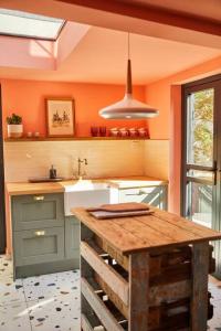 a kitchen with a wooden table and a sink at The Old Stout House - interior designed, converted 1700s Inn in Rye