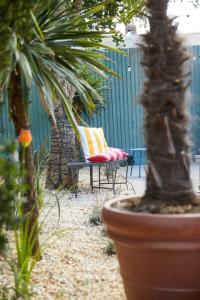 a patio with a chair and a palm tree at The Old Stout House - interior designed, converted 1700s Inn in Rye