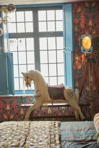 a toy horse sitting on a bed in a bedroom at The Old Stout House - interior designed, converted 1700s Inn in Rye