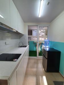 a kitchen with white cabinets and a black refrigerator at Zenmist properties - Studio Unit in Baguio