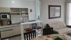 eine Küche und ein Wohnzimmer mit einem Sofa und einem Tisch in der Unterkunft Ap em São José com linda vista para o mar in São José