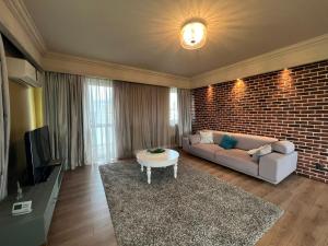 ein Wohnzimmer mit Sofa und Ziegelwand in der Unterkunft Lake View in Cluj-Napoca
