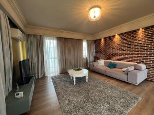 ein Wohnzimmer mit einem Sofa und einem TV in der Unterkunft Lake View in Cluj-Napoca