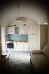 a kitchen with white cabinets and a couch in a room at villa damecuta B&B in Anacapri