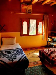 a bedroom with a bed and a window at maison isabel in Boumalne Dades