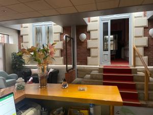 un ufficio con una scrivania e un vaso di fiori di Hotel La Poularde a Gien