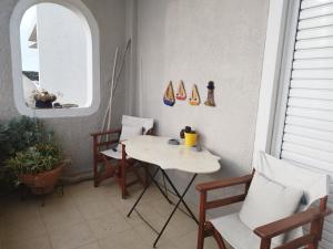 una veranda con tavolo, sedie e finestra di Indigo a Rafina