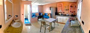uma cozinha com uma mesa e uma cozinha com cadeiras azuis em Tawada em Mirleft