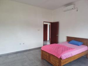 um quarto branco com uma cama com um cobertor rosa em sama sama villa em Midang