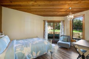 a bedroom with a bed and a chair and a window at Blue Heron Lookout in Freeland