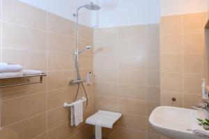 La salle de bains est pourvue d'une douche et d'un lavabo. dans l'établissement Hôtel Belesso, à Fontvieille