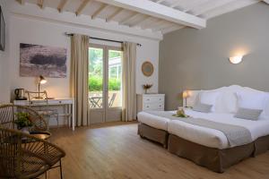 1 dormitorio con cama, escritorio y ventana en Hôtel Belesso, en Fontvieille