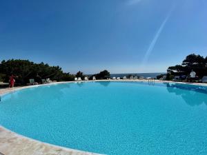 una gran piscina azul con un cielo azul en el fondo en Casa Lilly by Wonderful Italy en Porto Cervo